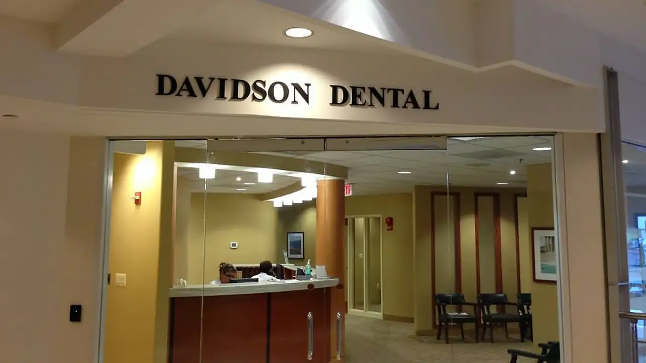 The reception of Davidson Dental Associates, with the practice's name above the glass entrance doors.