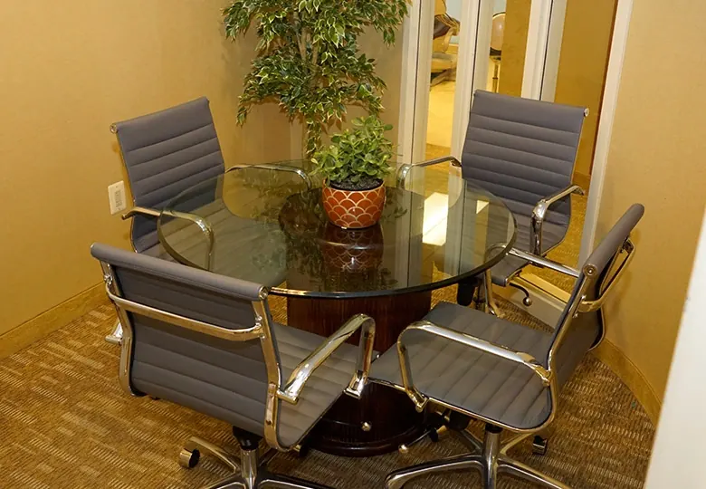 The consultation corner at Davidson Dental Associates, a round glass table with four chairs.